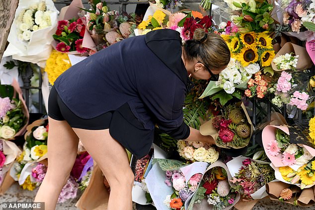 A mourner is seen leaving a bouquet of flowers outside Paddington's $2.5 million terrace.