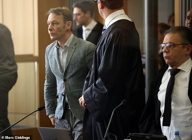 Brueckner is escorted to the courtroom in Braunschweig, near Hanover, flanked by guards.