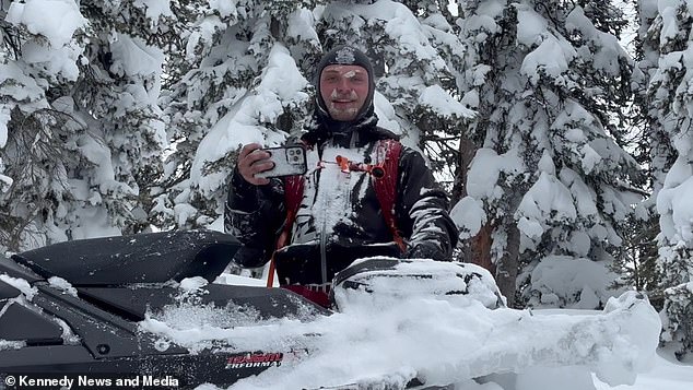 Mason Zak next to his snowmobile after the incident.