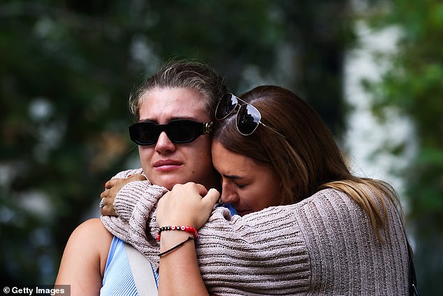 Friends comforted each other during the vigil (pictured)
