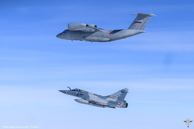NATO said that immediately after the first incident, French fighters were reassigned to a new mission, where they intercepted a Russian AN-72 flying in international airspace north of Poland.  Pictured: A French plane beneath a Russian AN-72 in an image released by NATO.