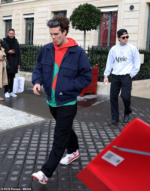 Cruz cut a colorful figure in a vibrant green and red hoodie layered under a navy bomber jacket and paired with statement sneakers.