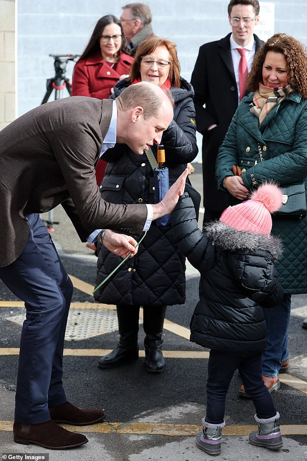 Prince William high fives a girl called Florence Boyle while visiting Wrexham today