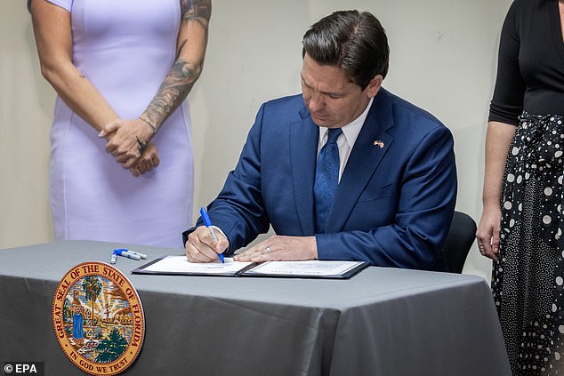 DeSantis, who celebrated the firings on social media, is seen signing a bill during a news conference at the Palm Beach Police Department headquarters in Palm Beach on Thursday. He has passed several laws to remove DEI lessons and literature from schools since he became governor in 2019.
