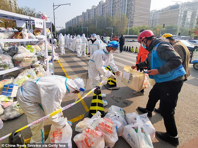 Workers organize food supplies at the Tiantongyuan residential complex where residents are locked down to stop the spread of the Covid-19 coronavirus on November 3, 2021 in Beijing.
