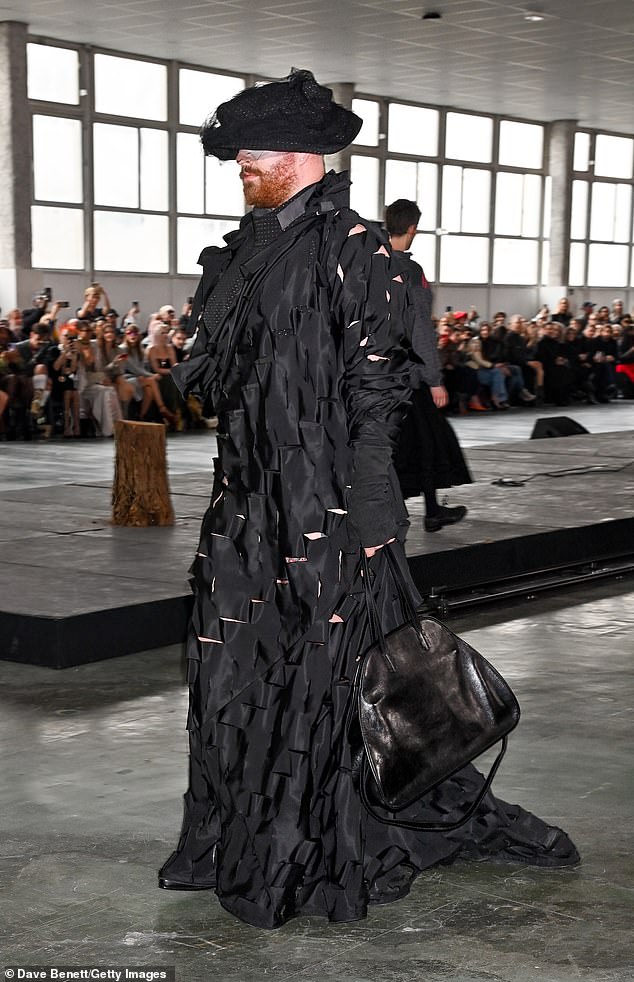 The floor-length dress featured layers of ruffled and ripped fabric that she paired with a black leather bag.