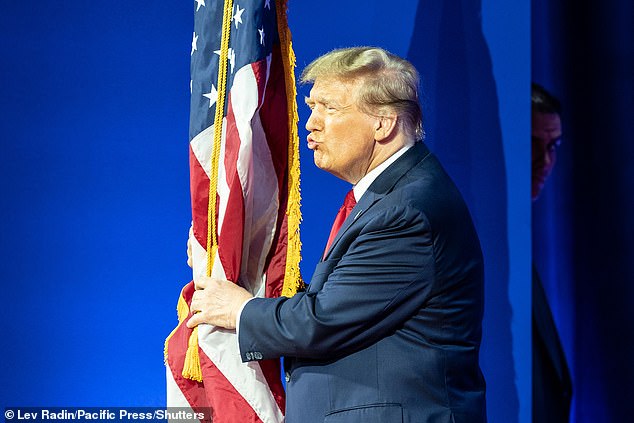 Former President Donald J. Trump kisses the American flag as he arrives on stage during the 2024 CPAC Conference at Gaylord National Resort & Convention Center in Washington DC