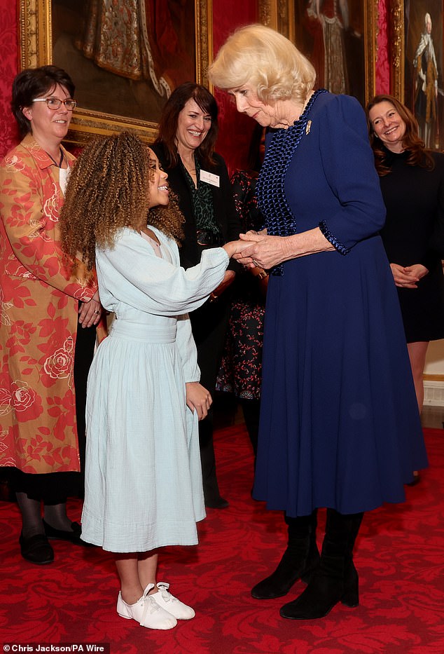 Camilla shakes hands with nine-year-old Skylar Copeland during a reception at Buckingham Palace in London on February 28.