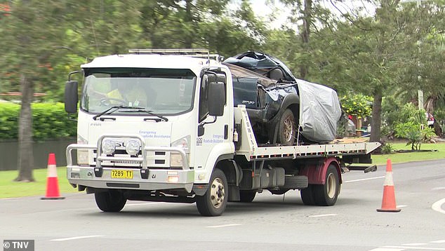 The crashed Mazda BT-50 ute is pictured on the back of a tow truck