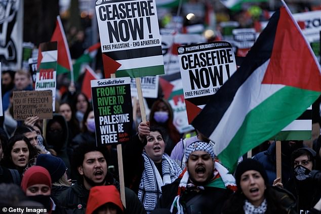 People hold banners and Palestinian flags during a demonstration calling for a ceasefire, outside parliament as MPs consider a motion on Gaza on February 21.