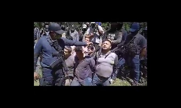 An alleged gang member from Los Tlacos points his gun at one of the 20 members of La Bandera in 2021