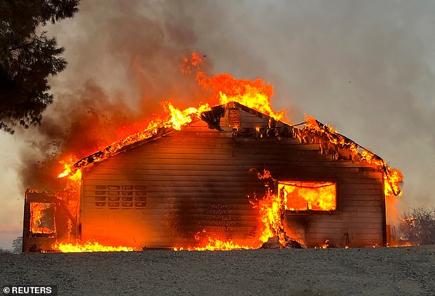 A view shows a house on fire during the Fairview Fire near Hemet, California, U.S., September 5, 2022. The wildfires have raised costs for insurers, which have increased premiums.