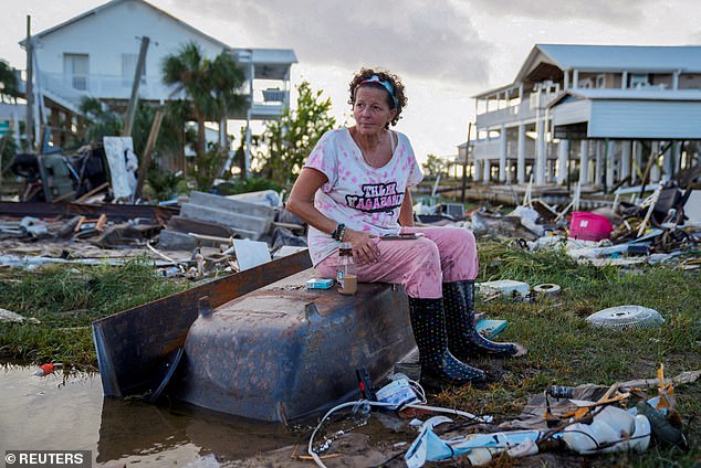 Jewell Baggett, 51, sits in a bathtub in the rubble of her home in Horseshoe Beach, Florida, which Hurricane Idalia reduced to rubble in August. Bad weather has affected insurance premiums