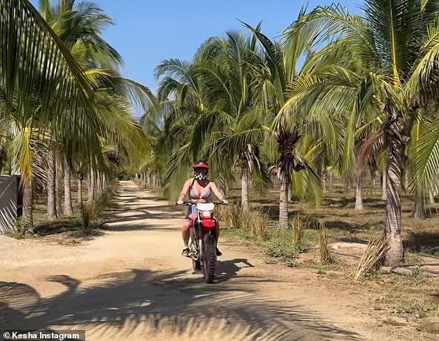 The artist also shared a short clip of her riding a red motorcycle down an empty dirt road lined with green palm trees.