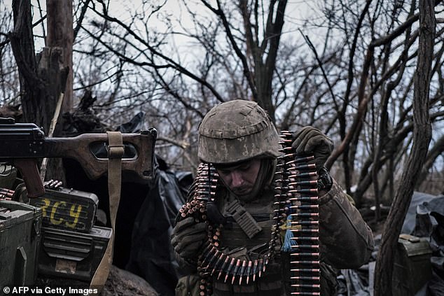 A Ukrainian volunteer army soldier prepares ammunition to fire on Russian frontline positions near Bakhmut.
