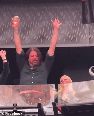 In the short clip, Grohl can be seen swaying and closing his eyes while holding a drink while U2 performs their hit song Beautiful Day.
