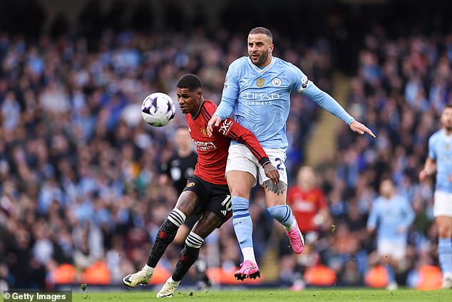 Rashford falls to the ground as Kyle Walker tries to regain possession for City