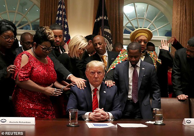 African American supporters, including Terrence Williams, Angela Stanton and Diamond and Silk, pray with Trump in the Cabinet Room of the White House in February 2020.