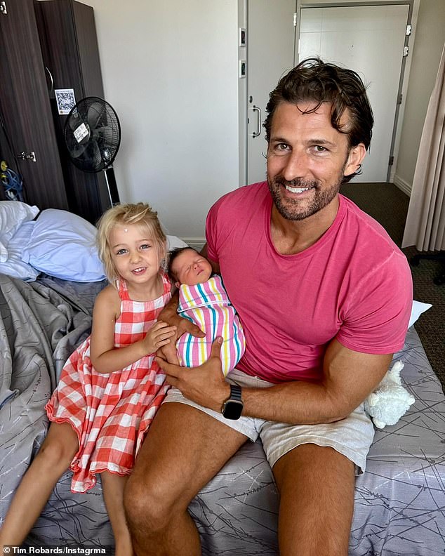 In a final image, Tim is seen proudly holding Ruby with his daughter Elle. In the photo