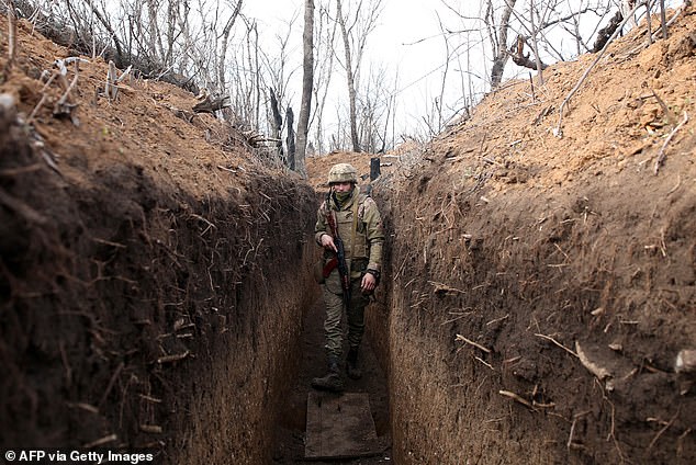 A Ukrainian soldier walks in a trench on the front line with Russian-backed separatists near the town of Krasnogorivka, Donetsk region.