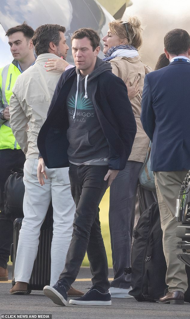 Eugenie's husband Jack Brooksbank was photographed on the runway wearing a gray hoodie under a cardigan and black jeans.
