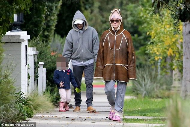 She kept a low profile as she walked in a pink hat, sunglasses and a brown suede hooded jacket, paired with joggers and slippers.
