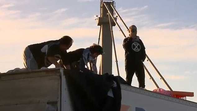Police have since removed the climate activists (pictured) who were on top of the truck blocking traffic.