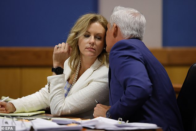 Attorney John Merchant speaks with his wife and co-counsel Ashleigh Merchant during the hearing on the Georgia election interference case.
