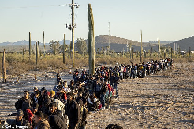 Immigrants line up at a remote U.S. Border Patrol processing center after crossing the U.S.-Mexico border in December in Lukeville, Arizona.