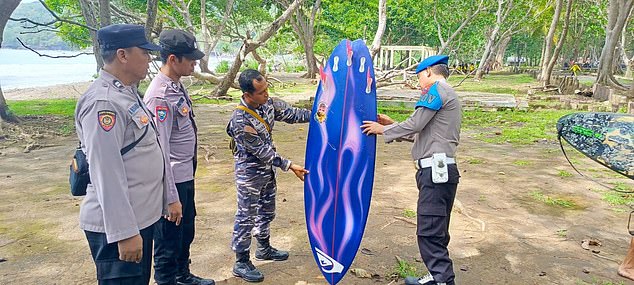 Indonesian police examine a broken board on the beach where Kitzler disappeared under the waves