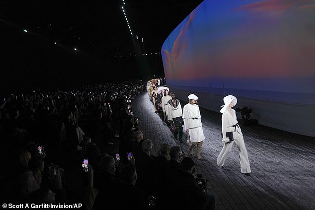 The models walked along a semicircular catwalk in front of a projection screen.