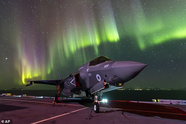 An F-35B Lightning aircraft is parked on a flight deck of the Royal Navy aircraft carrier HMS Prince of Wales, under the northern lights off the coast of Norway, Sunday, March 3, 2024.