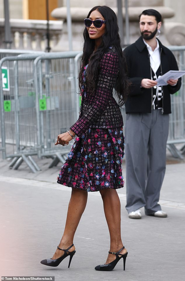 The supermodel looked elegantly refined in a black and purple above-the-knee dress with 3D applications reminiscent of flowers.