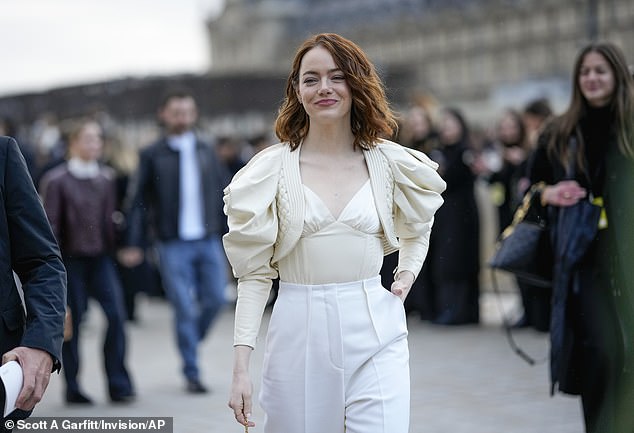 Emma paired the cream blouse with simple tailored white trousers while her brunette hair fell in natural curves.