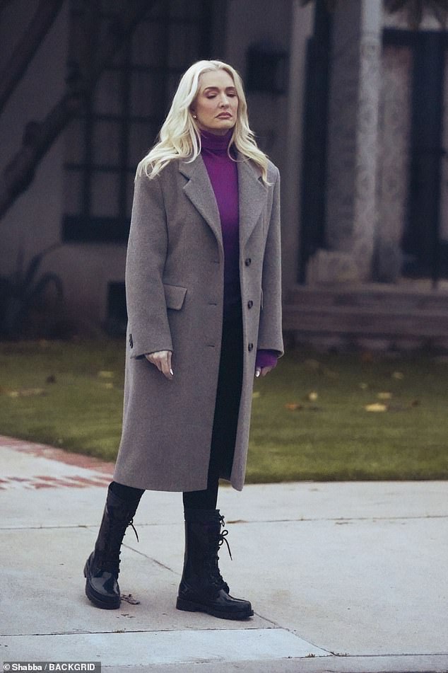 On one outing, she was photographed wearing a vibrant purple turtleneck and black pants under a long gray coat.  She paired the look with chunky black boots.