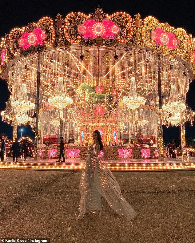 The supermodel wowed in an iridescent one-shoulder dress as she posed in front of fairground rides at the party.