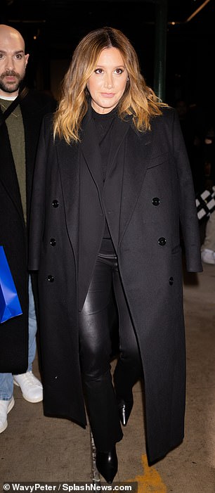 Tisdale wore a black maxi coat over a matching jacket, faux fur leggings, and ankle boots.
