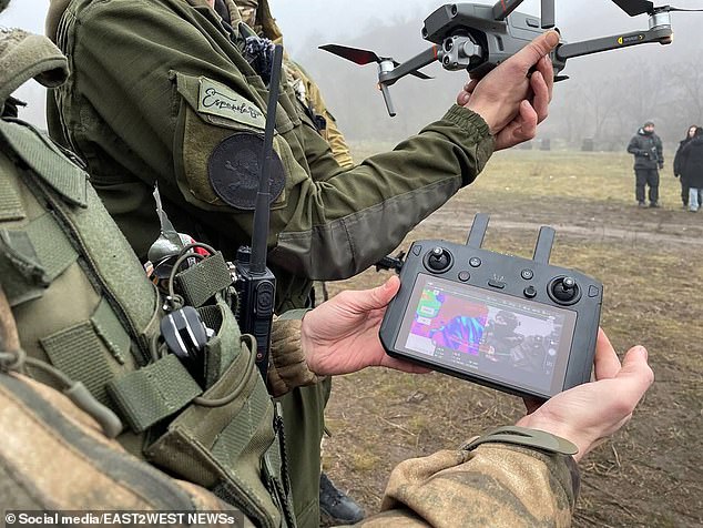 A drone operator, photographed with a Española badge on his arm, shows off his equipment