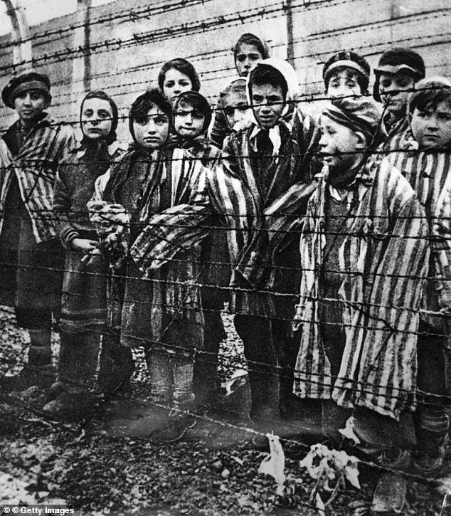 Children behind a barbed wire fence at the Auschwitz concentration camp in southern Poland