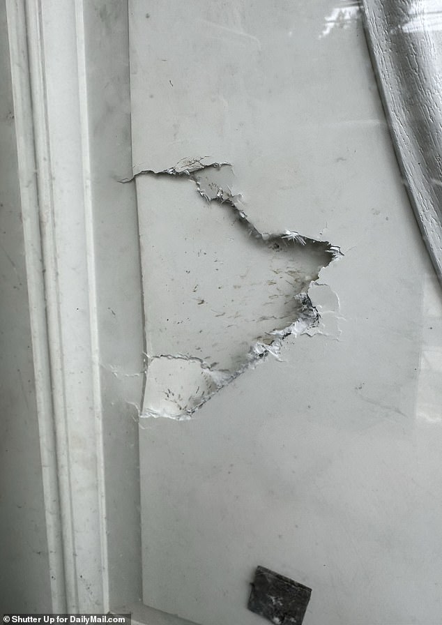 A broken door was visible at the Amityville property that was raided by police on Monday.