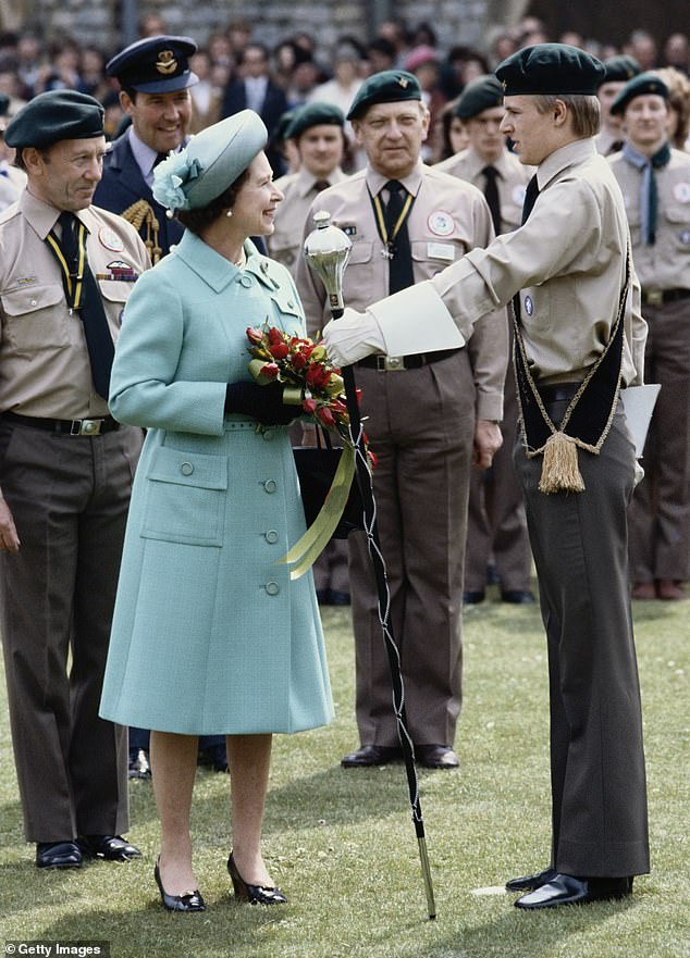 Queen Elizabeth II at a Queen's Scouts parade, in the grounds of Windsor Castle, wearing the same outfit to launch the Queen Elizabeth II ship, in April 1982.