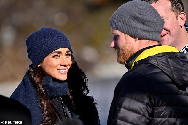 Meghan was bundled up and sported a navy blue hat as she smiled at Harry.