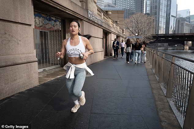 A runner runs along the downtown Riverwalk during an unseasonably warm winter day on February 27, 2024 in Chicago, Illinois.