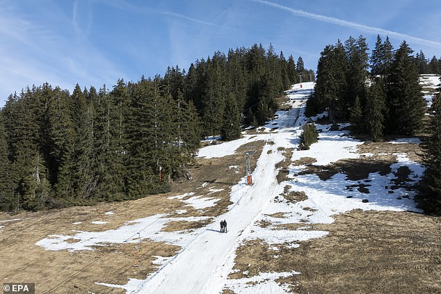 Skiers use a lift on a partly snow-covered ski slope at the alpine resort of Les Mosses in Ormont-Dessous, Switzerland, February 6, 2024. The mild weather of recent days in the Swiss Alps disrupted ski activity. alpine ski resorts