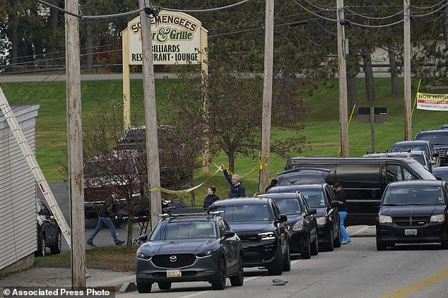 A body is carried out on a stretcher at Schemengees Bar and Grille in Lewiston, Maine