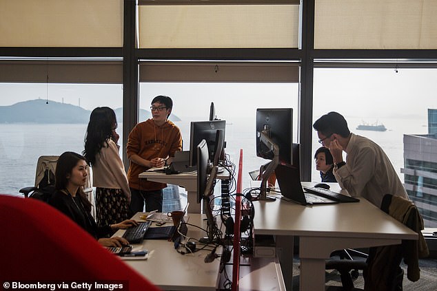 Employees work in front of computers at Microsoft Corp. Office and Experience Center during a media event for the opening of the workspace in Hong Kong, China.
