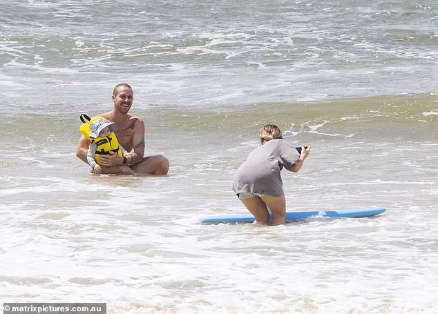 Jordie went shirtless and showed off his bulging biceps while taking his one-year-old son surfing on the Sunshine Coast.