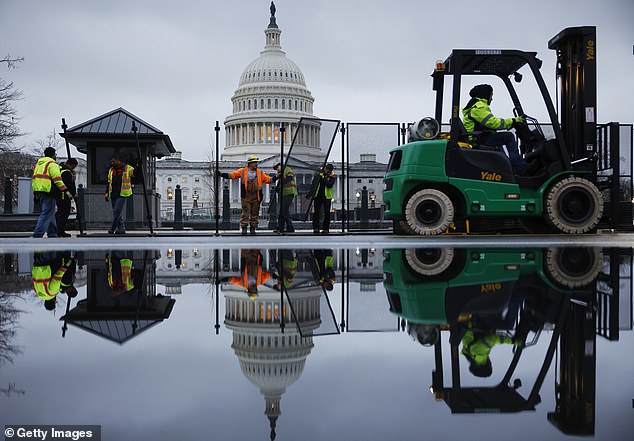 An eight-foot-high steel fence goes up around the U.S. Capitol the day before President Joe Biden delivers the State of the Union address.