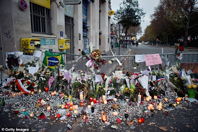 Flowers, candles and tributes line the pavement near the site of the Bataclan Theater terrorist attack on Friday, November 15, 2015 in Paris, France.
