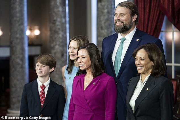 Britt photographed with Vice President Kamala Harris with her husband and two children as she was sworn into her seat in the United States Senate on January 3, 2023.